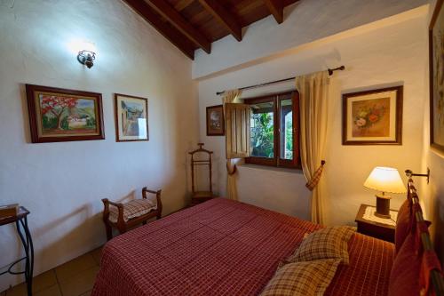 莫卡诺尔Casa Rural Tia Lucila的一间卧室设有红色的床和窗户。