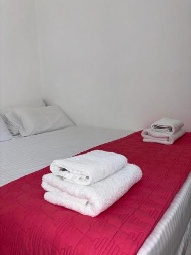 马克里亚罗斯Marena 2的红色毯子上一张带白色毛巾的床