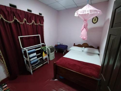 凯格勒AMBALAMA HOSTEL的一间卧室配有一张床和一个梳妆台