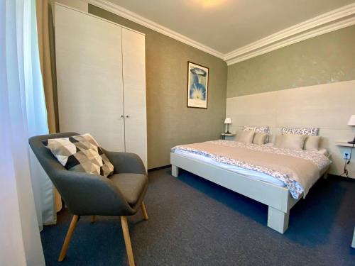 瓦茨Bellevue Vendégházak的一间卧室配有一张床和一把椅子