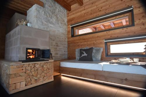 卡斯泰洛泰西诺Maso Stella的小木屋设有壁炉和床。