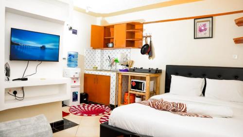 奈瓦沙Nelly fully furnished studios的卧室配有一张床,墙上配有电视。