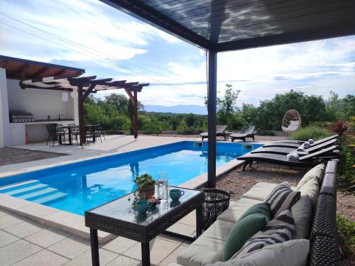 GaricaLazy 8 Villa的一个带沙发和桌子的游泳池