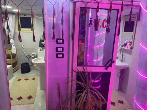 卢克索peace garden hostel & camp的浴室里粉红色的机器,有粉红色的灯光
