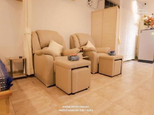 曼谷Super OYO Capital O 564 Nature Boutique Hotel的客厅配有两把椅子和凳子