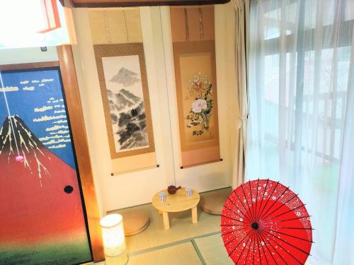 名古屋Masaki 1chome house的一间设有红色遮阳伞和一张桌子的房间