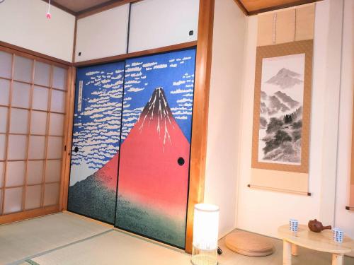 名古屋Masaki 1chome house的一间房间,有一扇门,上面有山画
