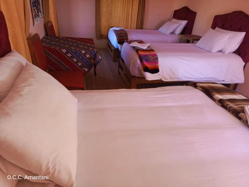 奥科苏尤Allpa Tika Lodge的酒店客房,配有3张带白色床单的床