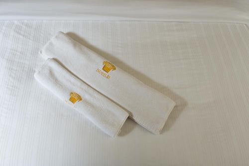 基加利Nobilis Hotel and Apartments的床上有两条白色毛巾