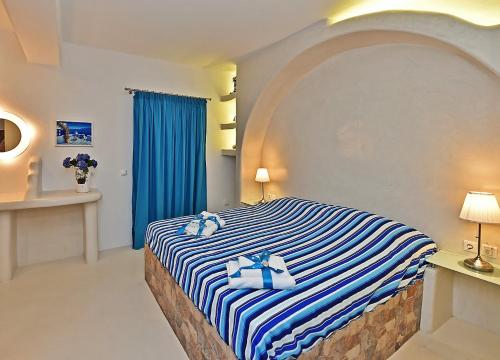 提诺斯TINOS AQUA PALAZZO的一间卧室配有一张蓝色和白色条纹的床