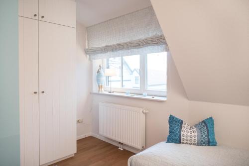 斯匹科罗格Spiekerhorst的一间小卧室,配有床和窗户