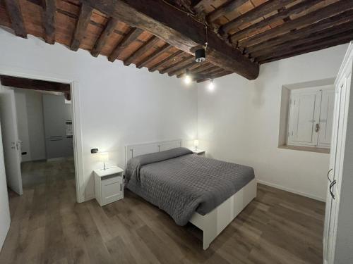 佩夏I due Ciueli的卧室设有白色墙壁和一张带两盏灯的床。