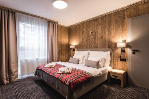 塔特兰斯卡斯特拉ARIETES MARMONT Resort的酒店客房,配有带两条毛巾的床