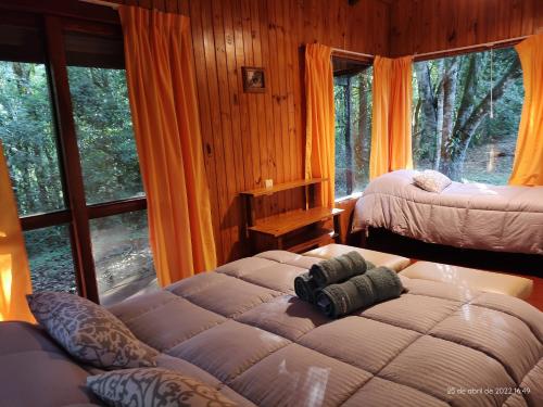埃尔索韦维奥Lodge Paraíso的一间卧室设有两张床和大窗户