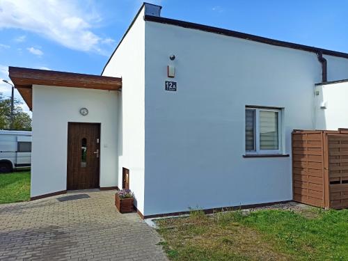 TargowagórkaMieszkanie na Wsi的一间白色的房子,设有棕色的门
