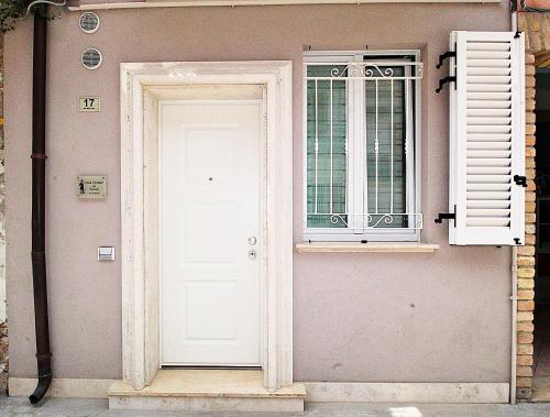 圣贝内代托-德尔特龙托Casa Vacanze del Vicario的白色的门和房子上的窗户
