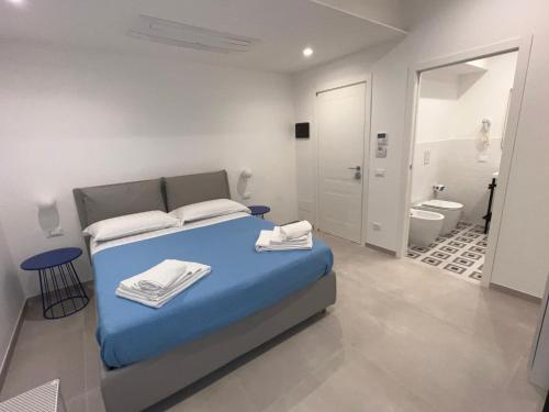泰拉奇纳Elios Badino B&B的一间带蓝色床的卧室和一间浴室