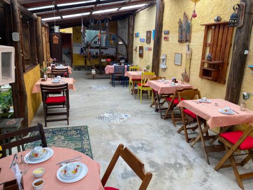 特雷索波利斯Pousada Jardim Secreto的一间餐厅,房间内设有粉红色的桌子和椅子