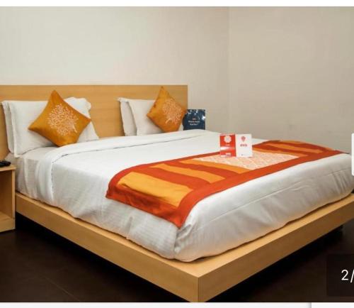 维沙卡帕特南Kamala Priya的一张配有橙色和白色枕头的大床