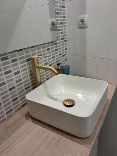 卡拉塔尤德Apartamentos Rúa Centro Calatayud & Balcony Apartament的浴室内有白色的盥洗盆和金色的排水沟