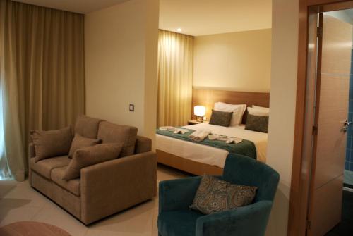 普拉亚Beramar Hotel的配有一张床和一把椅子的酒店客房