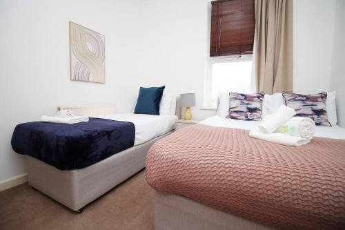 布里斯托Homely 2 Bedroom Apartment in Bristol for 5 Guests的一间卧室设有两张床和窗户。