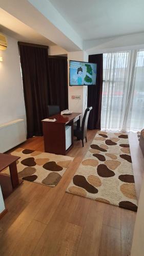阿拉德Pensiunea Select的一间设有书桌的房间和一间铺有地毯的房间