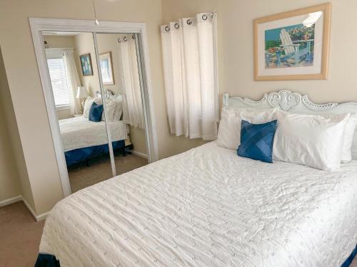 斩魔山Beach Bliss的卧室配有一张白色大床和镜子