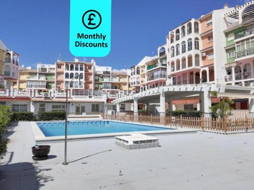 托雷维耶哈Blue Sea Unique Apartment in Torrevieja - Short walk to the beach的大型公寓,部分建筑前设有游泳池