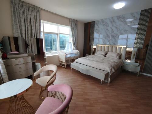 阿吉曼شقة فخمة وواسعة غرفتين luxury and big 2BR的卧室配有一张床和一张桌子及椅子