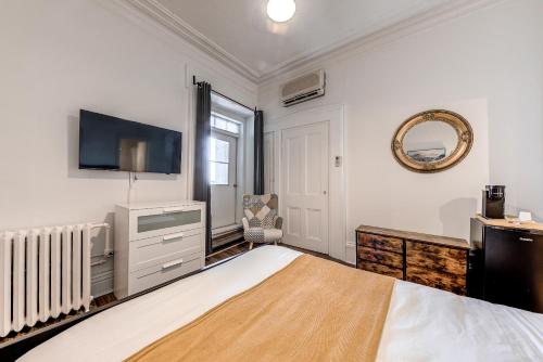 魁北克市Hôtel Automatisé Manoir des Remparts的一间卧室配有一张床和一台平面电视