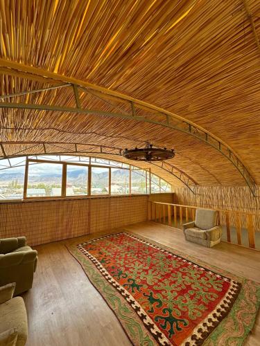 博孔巴耶沃Amirhan Guest house的大房间设有地毯、沙发和椅子