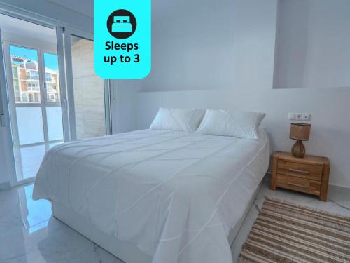 托雷维耶哈Blue Sea Unique Apartment in Torrevieja - Short walk to the beach的白色卧室内的一张白色床,设有床头柜