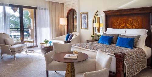 迪拜迪拜朱美拉海滩唯一度假村的酒店客房配有带蓝色枕头的特大号床。