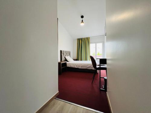 巴纽Auberge de Bagneux的客房设有带一张床和一张书桌的卧室。