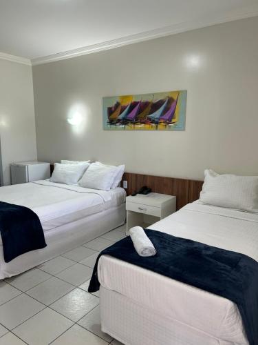 巴纳伊巴那提勒斯酒店的酒店客房设有两张床,墙上挂有绘画作品