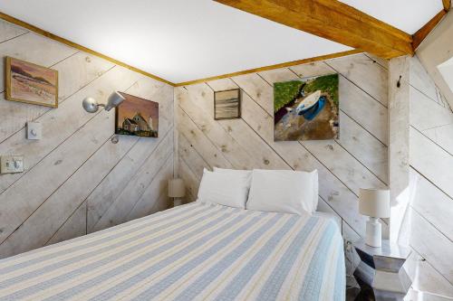 TrevettThe Dome House的卧室配有一张床铺,位于带木墙的房间内