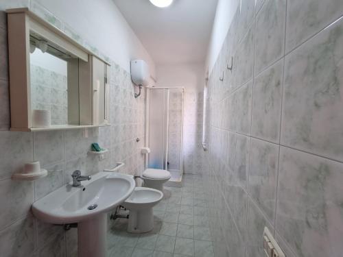 克罗帕尼Villaggio Camping Lungomare的白色的浴室设有水槽和卫生间。