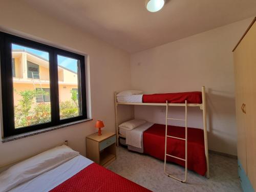 克罗帕尼Villaggio Camping Lungomare的一间卧室设有两张双层床和一扇窗户。