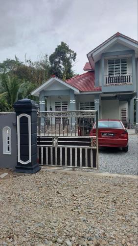 Pasir MasIIY Homestay的停在房子前面的红色汽车
