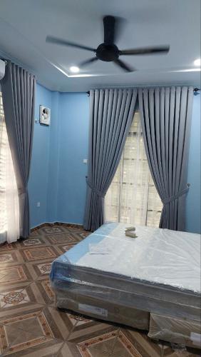 Pasir MasIIY Homestay的一间卧室配有一张床和吊扇