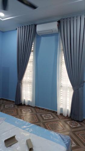 Pasir MasIIY Homestay的一间拥有蓝色墙壁的卧室和一个带窗帘的窗户