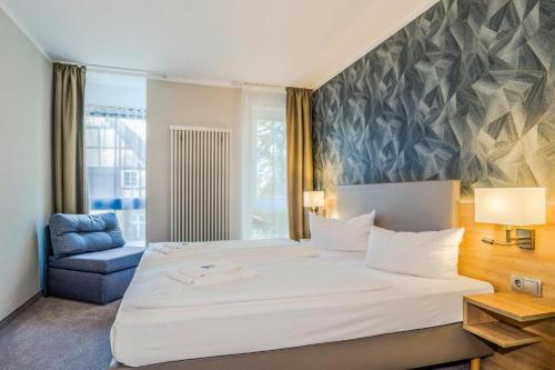 柏林阿尔特市场酒店的卧室配有一张白色大床和一张蓝色椅子