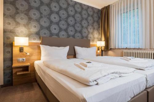 柏林阿尔特市场酒店的配有白色床单的酒店客房内的两张床