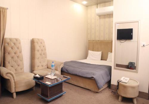拉合尔Hotel Royal Fort的配有一张床和一把椅子的酒店客房
