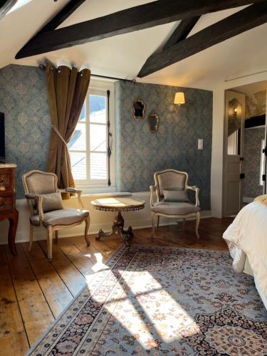 滨海布洛涅Chambres d'hôtes du château的一间卧室配有两把椅子、一张床和窗户