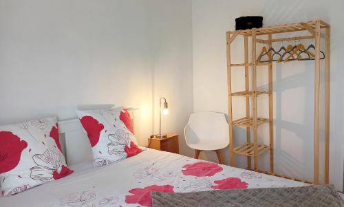 阿斯克新城Beau T3 à 5 min du Grand Stade avec parking gratuit的一间卧室配有红色和白色枕头的床
