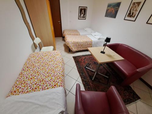 卡拉尔佐Lunga Via Delle Dolomiti的客房设有两张床、一张桌子和一张沙发。