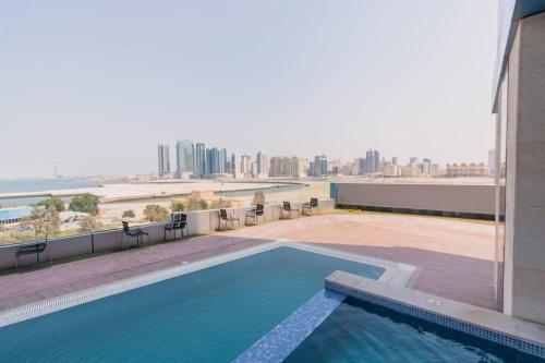 麦纳麦Era View Bahrain Luxurious 1 bedroom, Sea view and waterfront的游泳池位于大楼顶部,享有城市美景