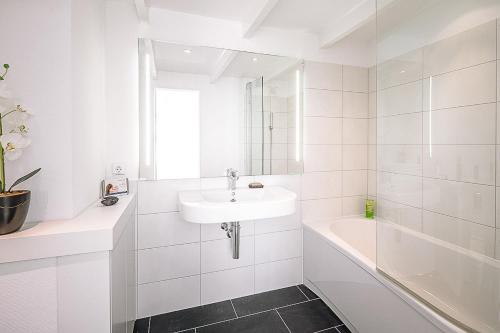 斯匹科罗格Walfisch的白色的浴室设有水槽和浴缸。